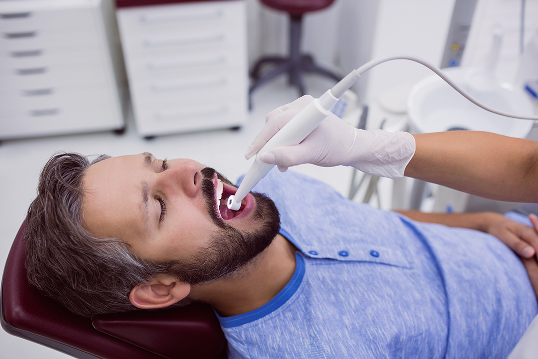 Limpieza dental por ultrasonido Dentista realizando una limpieza dental por ultrasonido a un paciente.